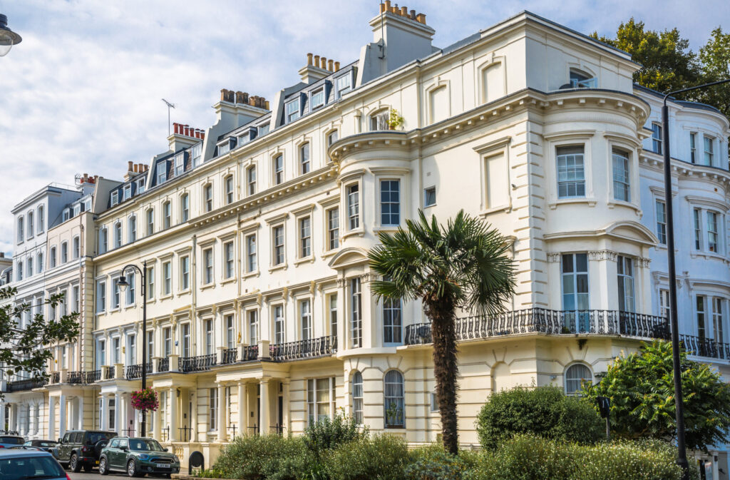 Terraced white stucco fronted houses in Prime Central London's Notting Hill, with tree