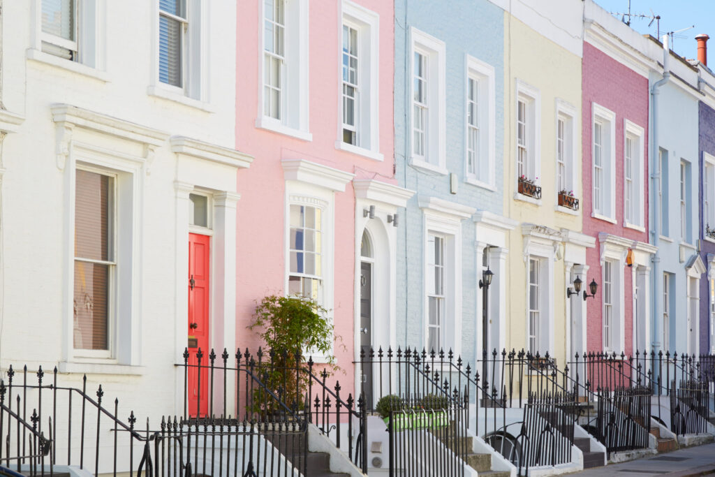 Pretty terrace of pastel coloured house with wrought iron railings